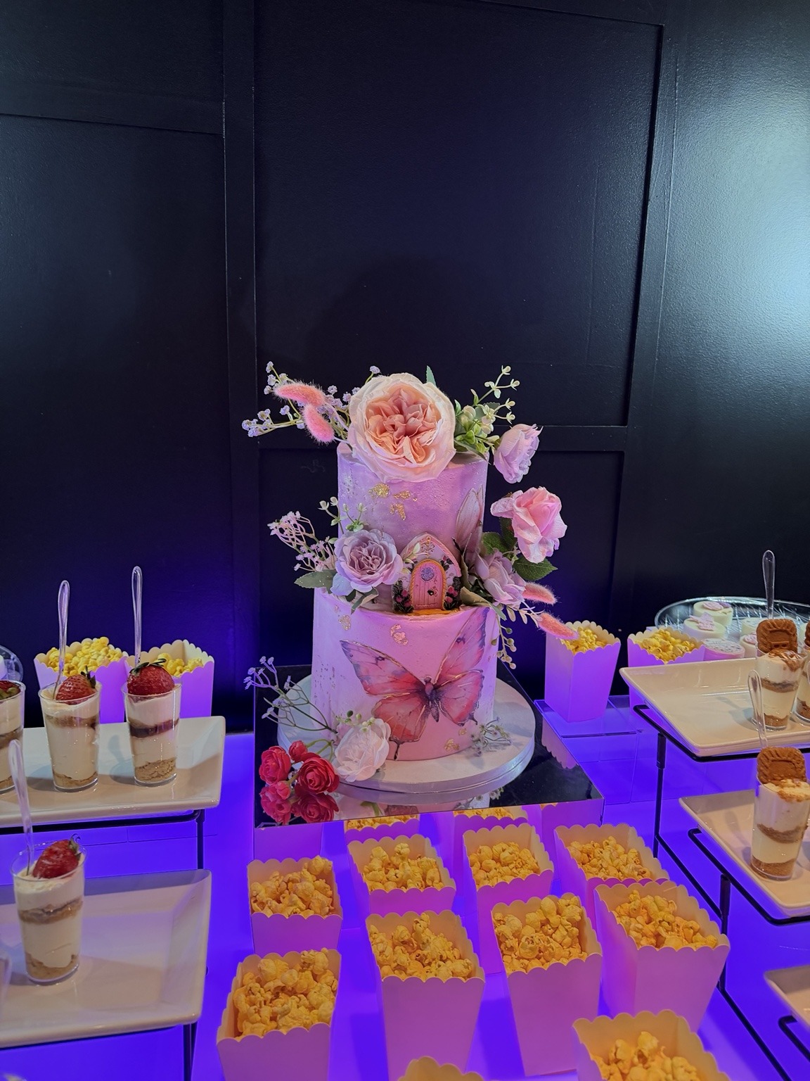 Butterfly cake and dessert table with pink and purple details